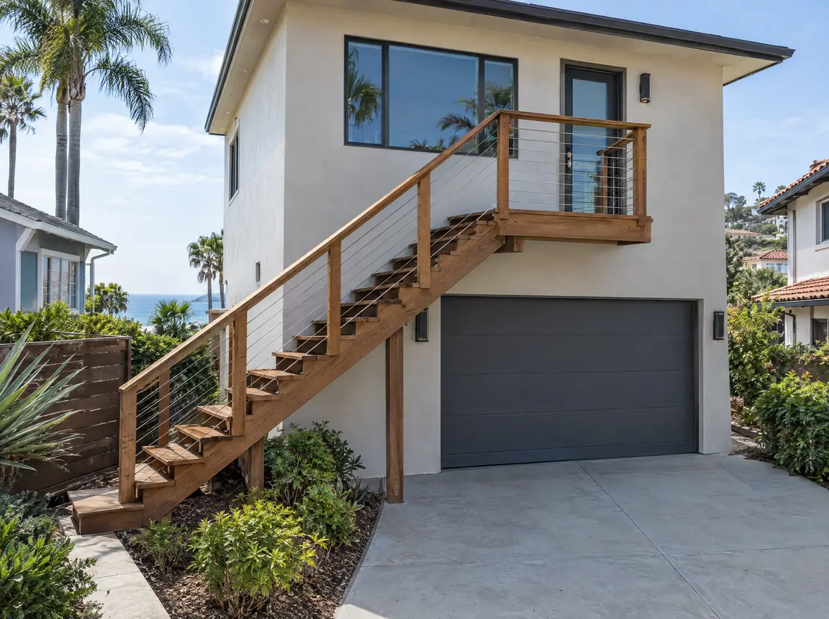 Exterior wood stair leading to a newly built unit above a garage, smooth stucco, coastal California neighborhood