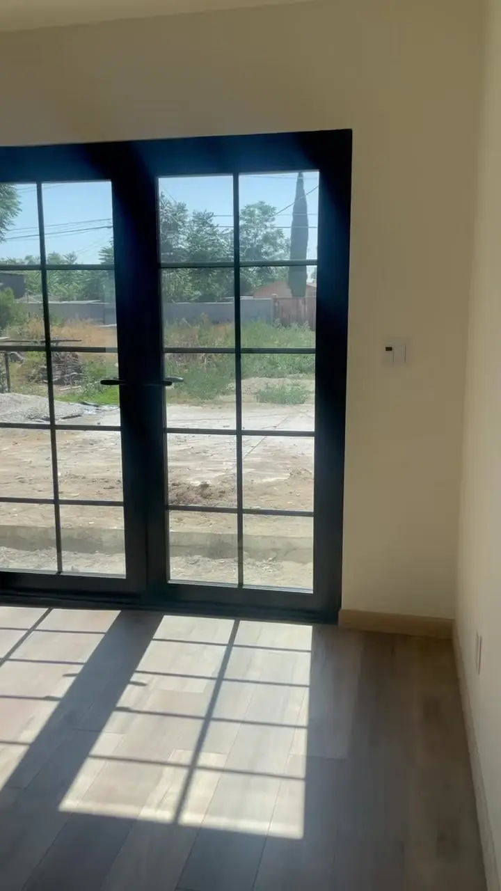 Black steel French doors opening to the yard