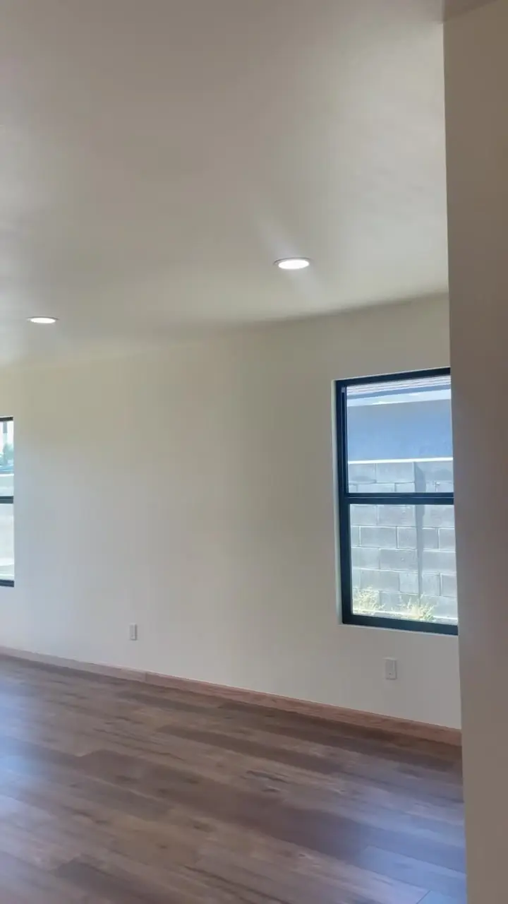 New room in an addition with black-framed windows and wood floors