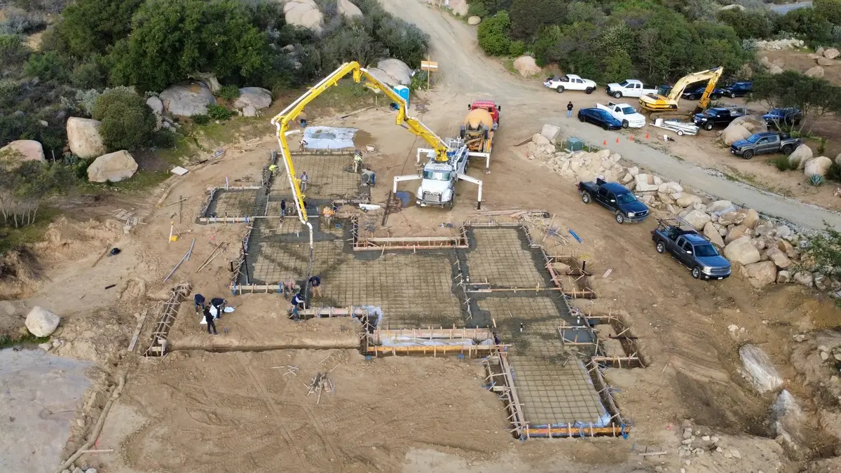 Aerial view of a concrete pump truck pouring a home foundation