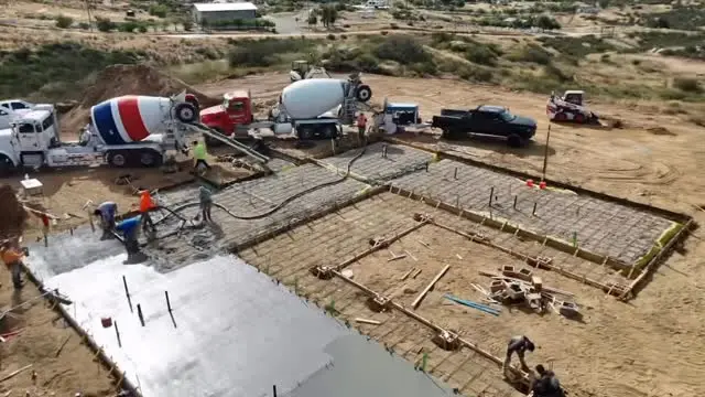 Hacienda style custom home in wine country in Temecula, CA: concrete trucks and a pump pouring a custom home foundation