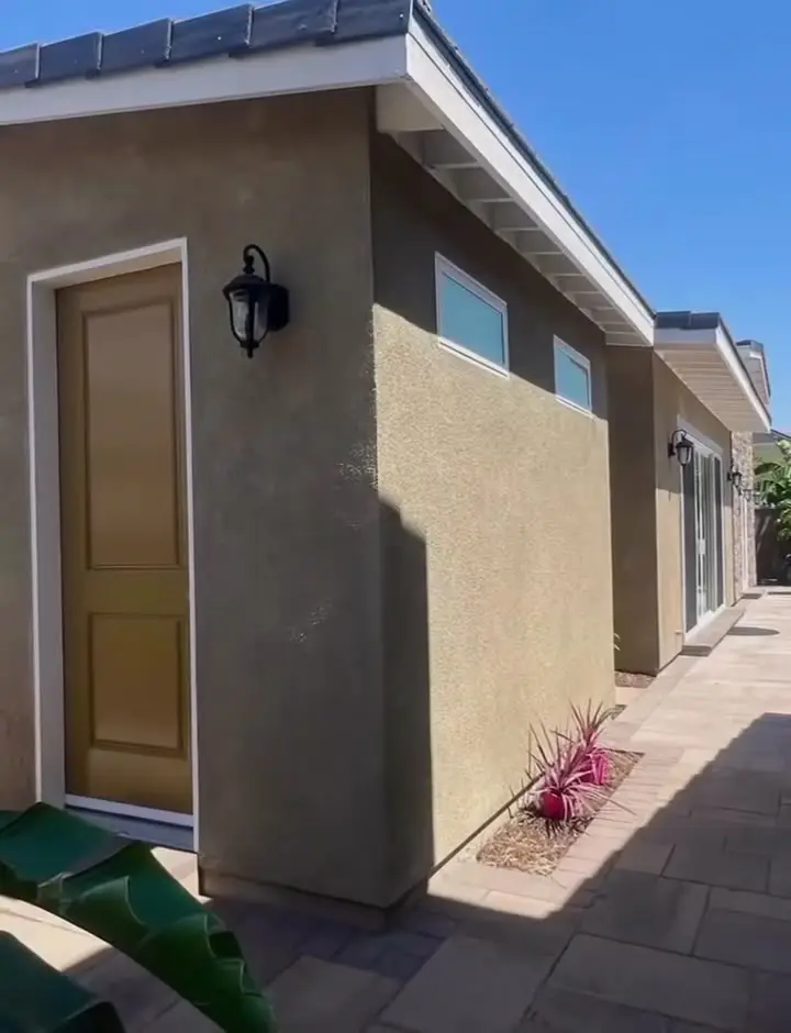 893 sq ft ADU and pool house, two phases in Fontana, CA: side entry door and stucco wall of a detached adu