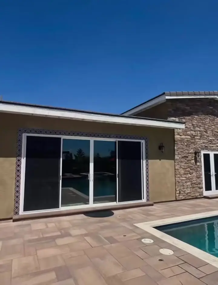 893 sq ft ADU and pool house, two phases in Fontana, CA: pool house adu with sliding doors beside a backyard pool