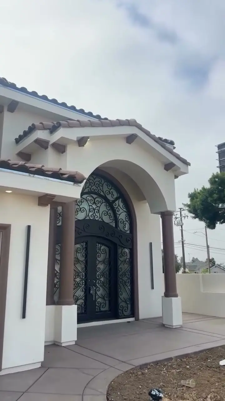 Arched wrought-iron entry on a new Spanish-style custom home