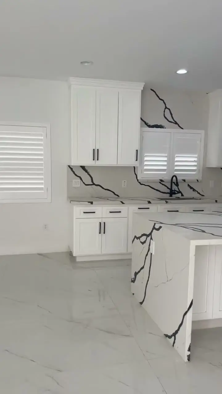 White kitchen island and plantation shutters in a new custom home